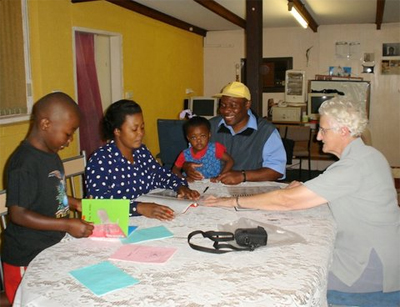 Sr. Anastasia teaching English to a Congolese family